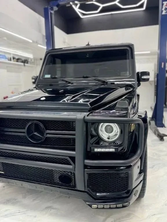 Mercedes Classe G noire entre deux ponts élévateurs